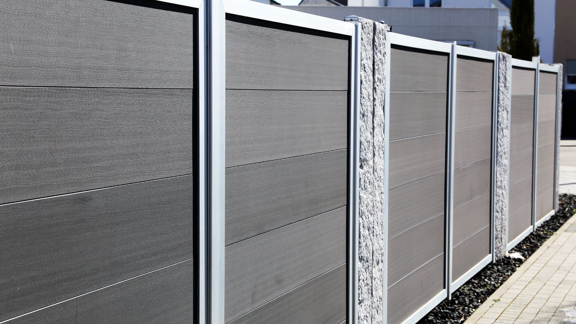 Modern modular fence with gray panels and stone columns